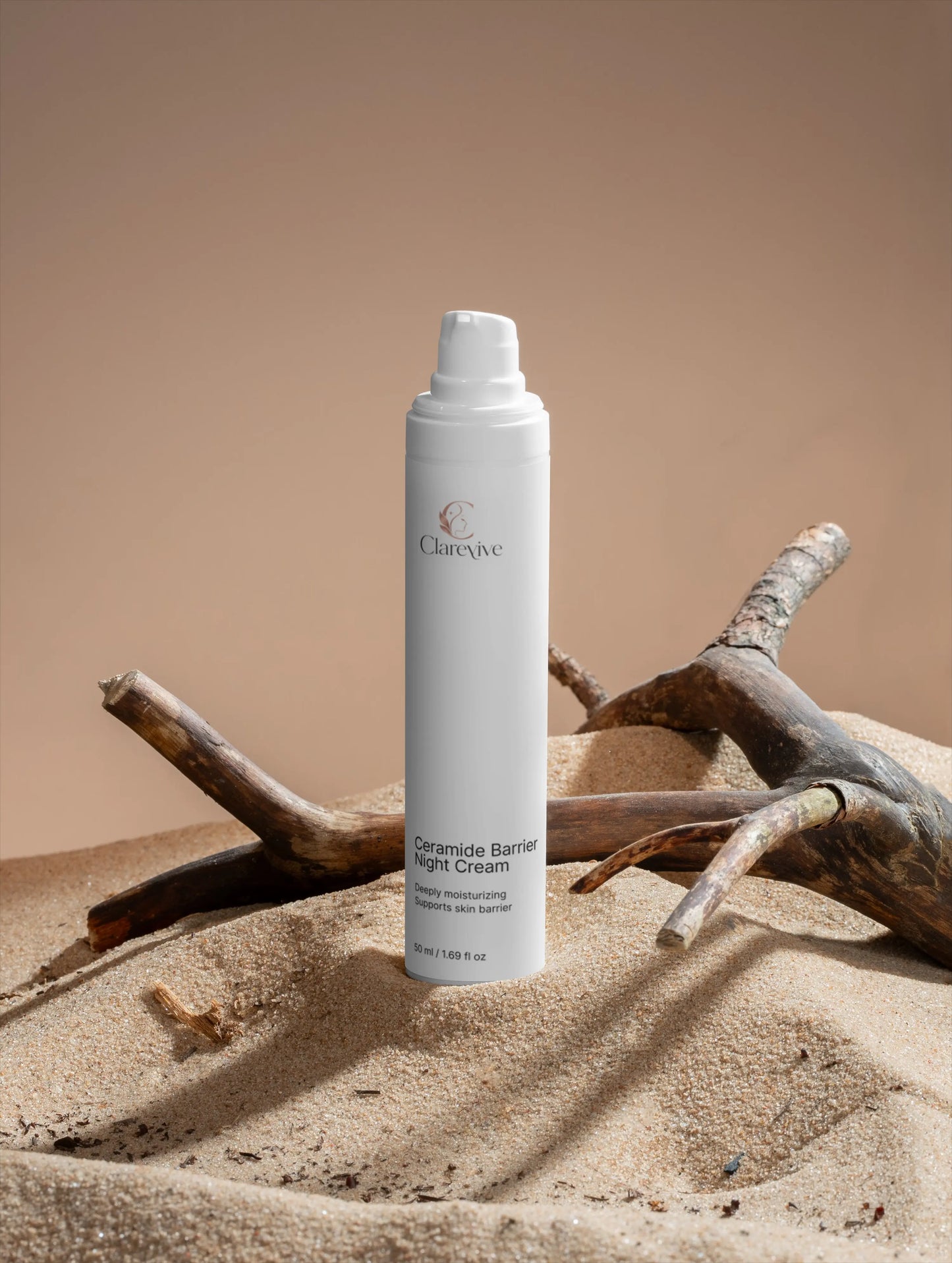 White pump night cream bottle standing among sand and driftwood
