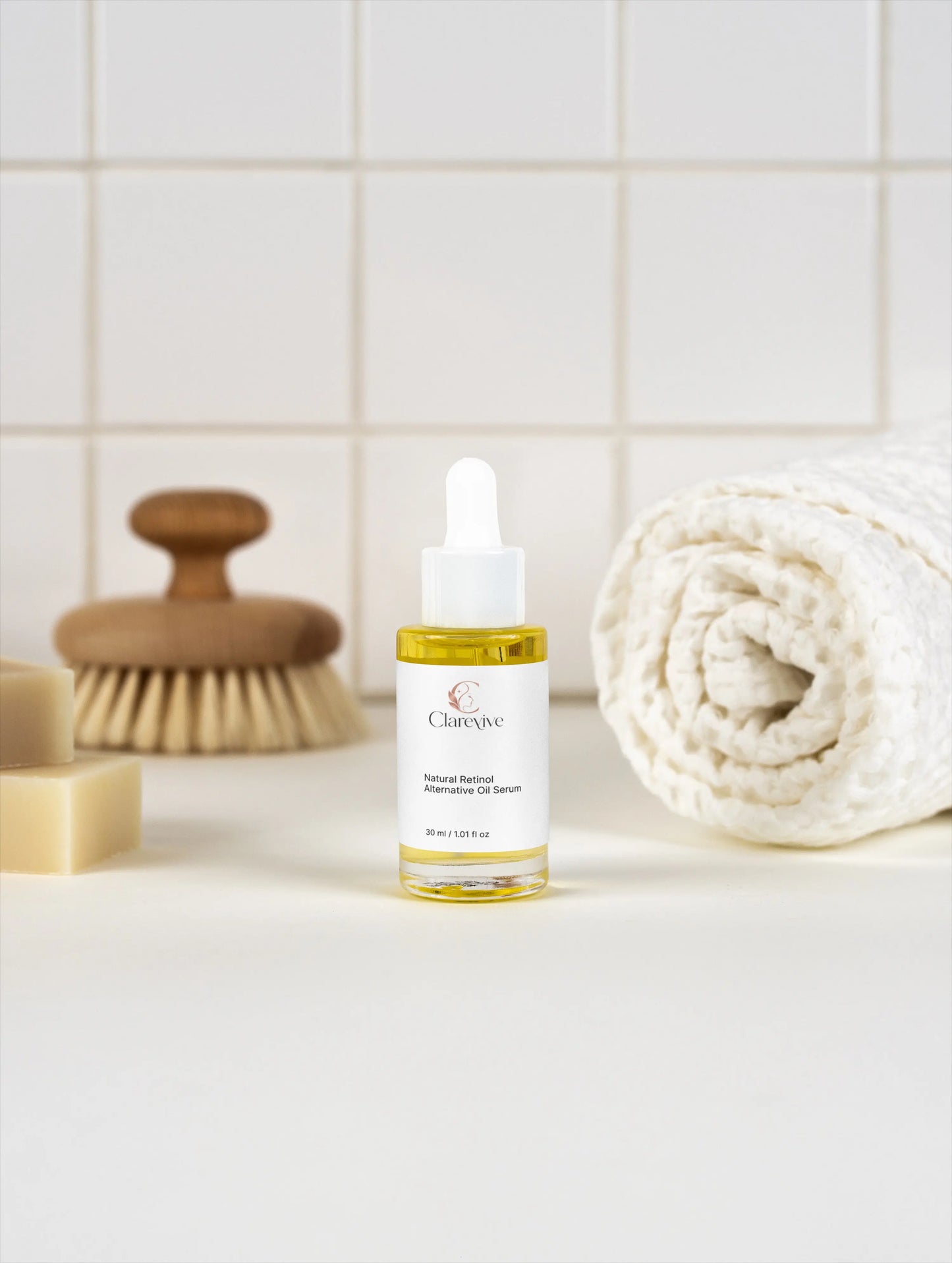 Clarive retinol alternative oil serum bottle with white dropper beside a rolled towel