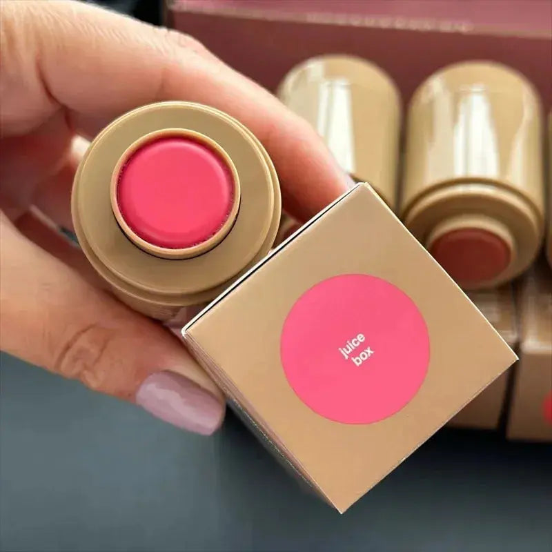 Pink lip glaze balm in round beige container, cap open in hand