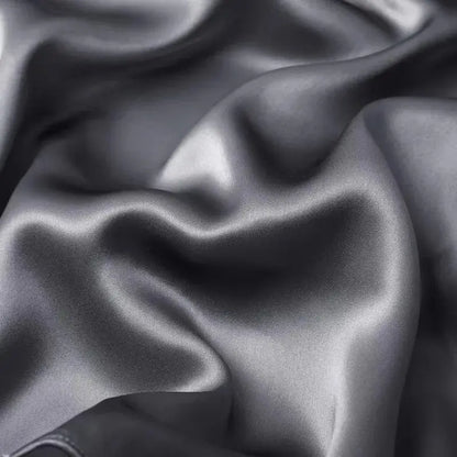 Dark grey silk pillowcase fabric close-up with glossy satin texture