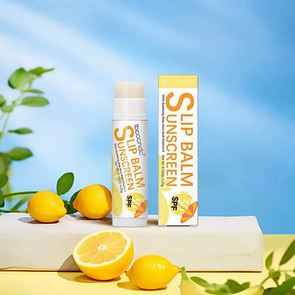Banana lip balm SPF 30 stick with lemons and citrus on a tabletop