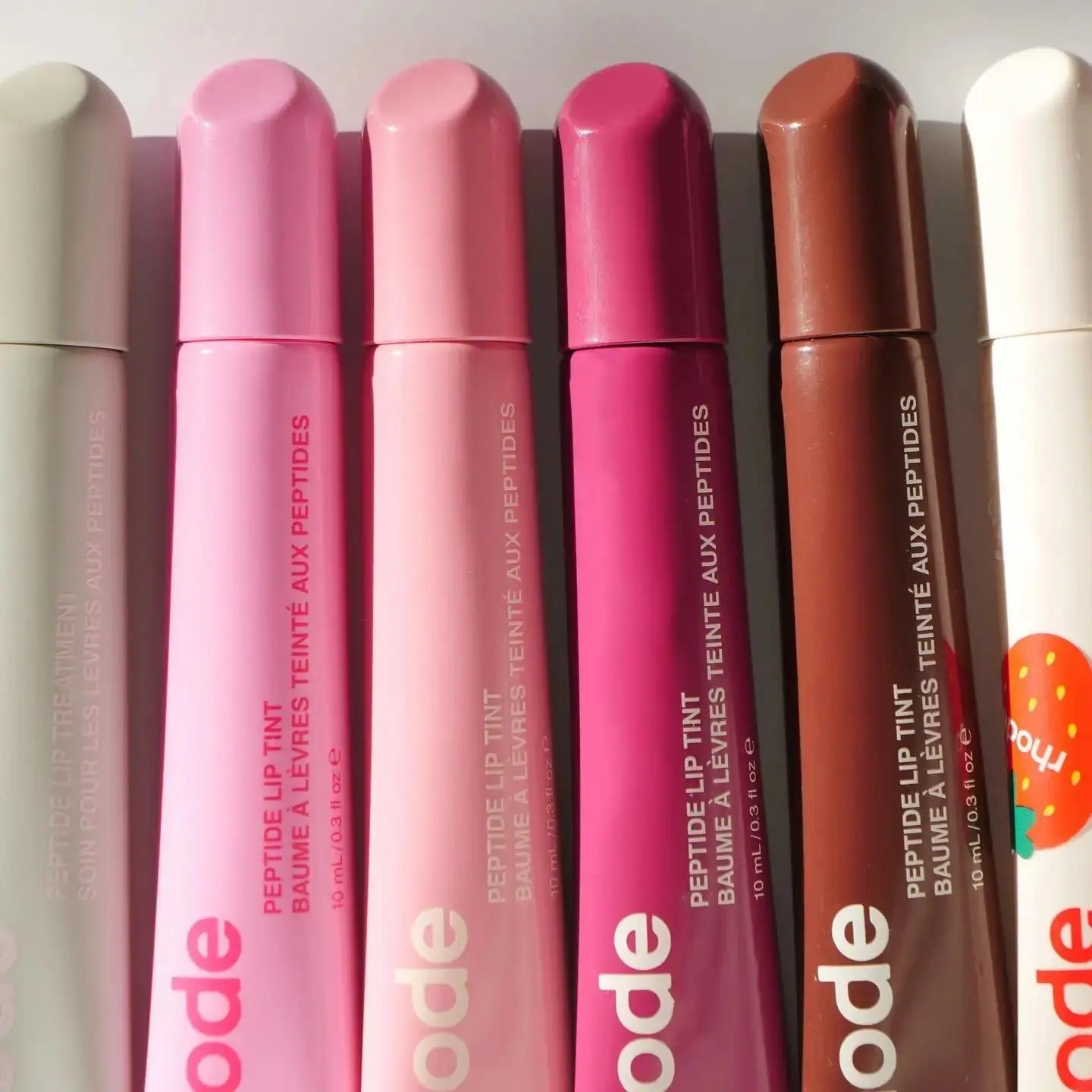 Set of Rhode lip gloss tubes in pink, magenta, brown, and cream shades