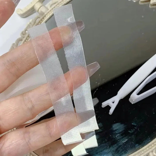 Sheer facial lift tape strips on hand, transparent textured adhesive