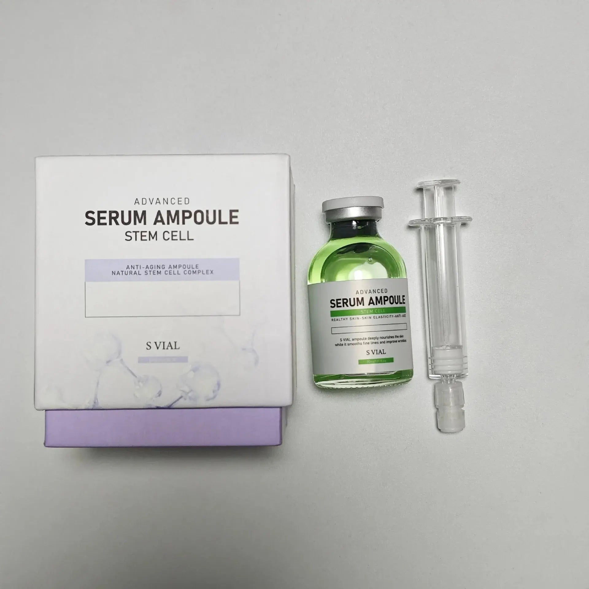 Serum ampoule set with green glass bottle, white box, and clear dropper vial
