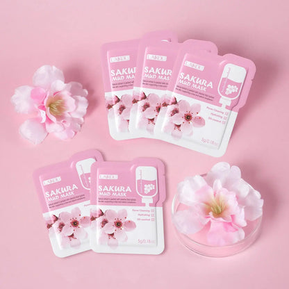 Pink Sakura mud mask face mask sachets arranged on a pastel background