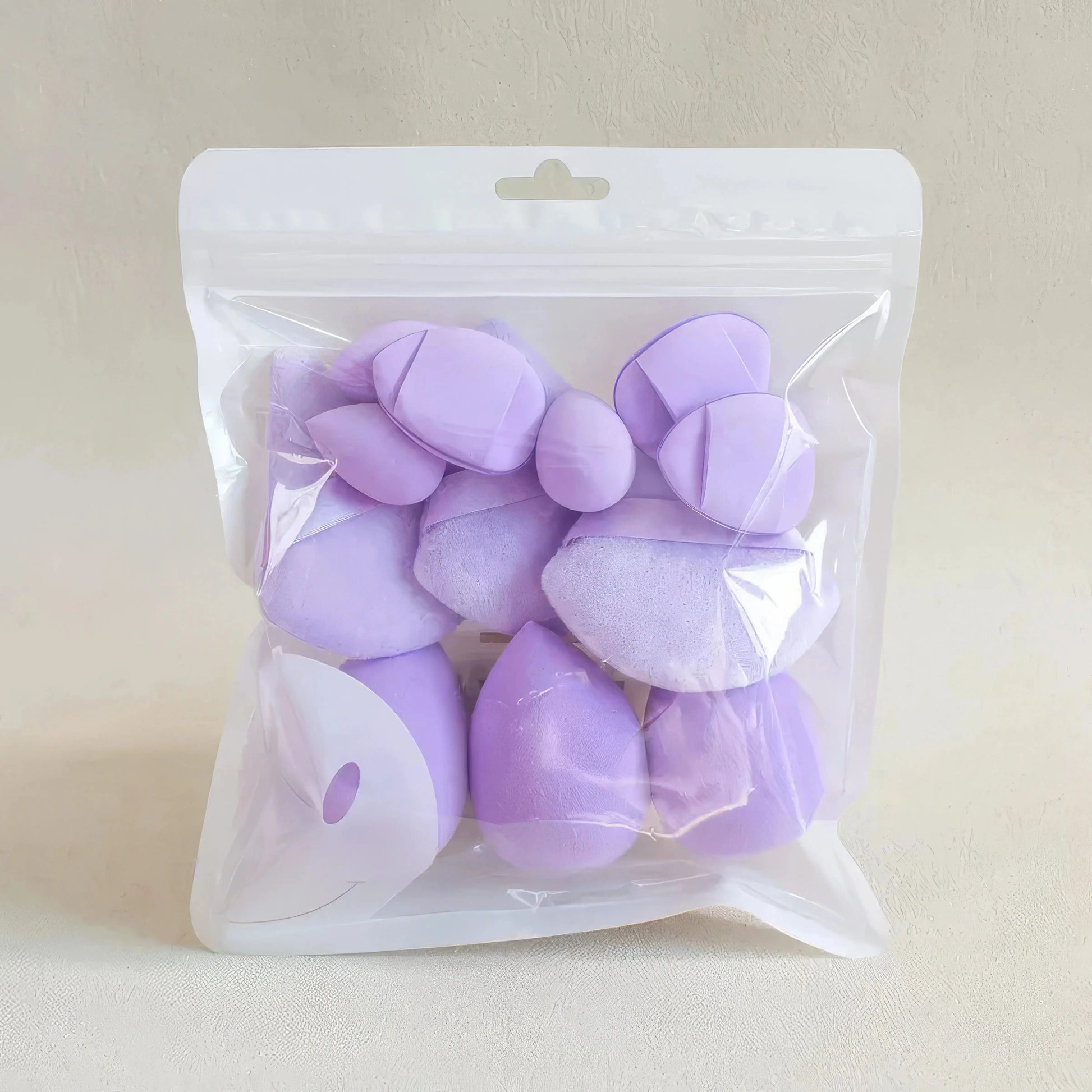 Lavender egg-shaped makeup sponges sealed in a clear plastic pouch.