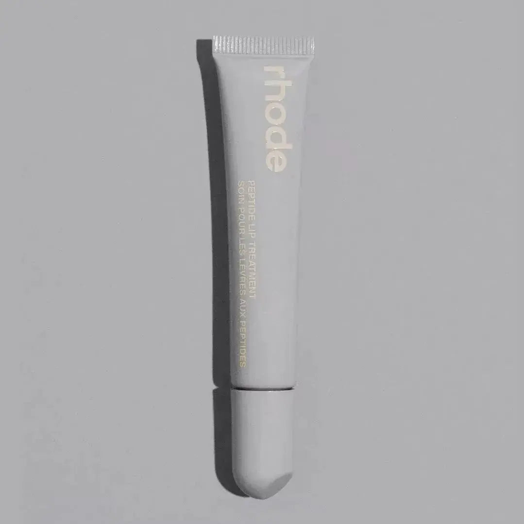 White lip glaze tube with applicator tip, branded “rhode” plump moisturizing lip gloss