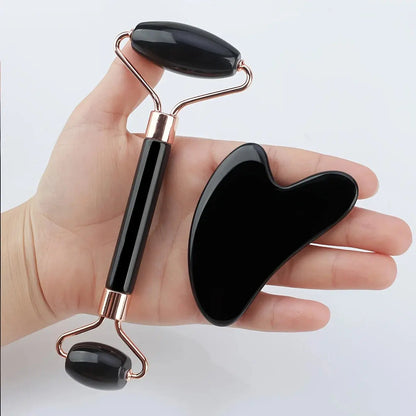 Facial roller with black stone heads and rose-gold frame held in hand