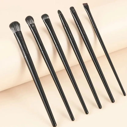 Set of 6 eye makeup brushes with dark handles and soft bristles, angled view