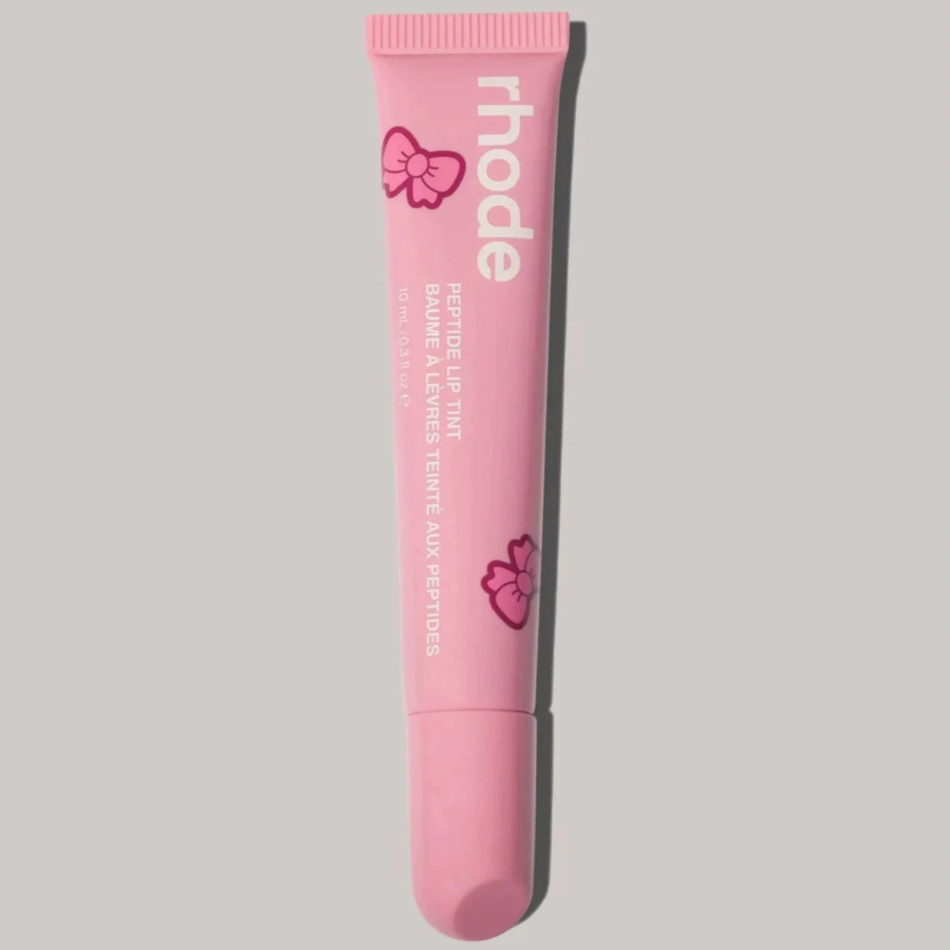Pink Rhode lip balm tube with bow graphics and squeeze tip