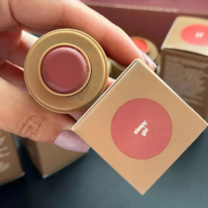 Pink lip glaze balm in round beige container with boxed color label