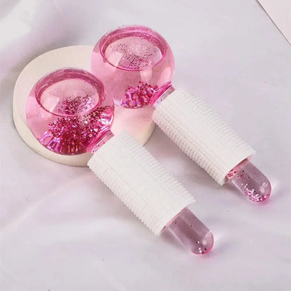Two pink glitter ice crystal ball rollers with textured white handles, pair on light surface