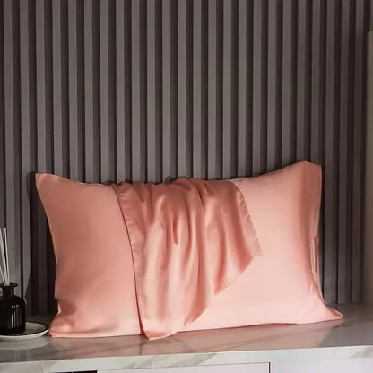 Rose-pink silk pillowcase with satin sheen and centered folded flap