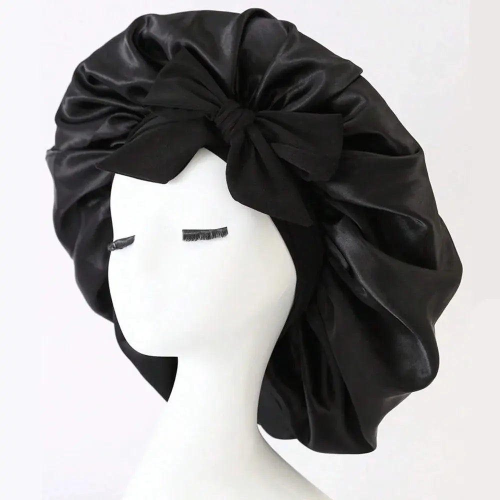 Black satin hair bonnet with gathered crown and front tie bow for sleep