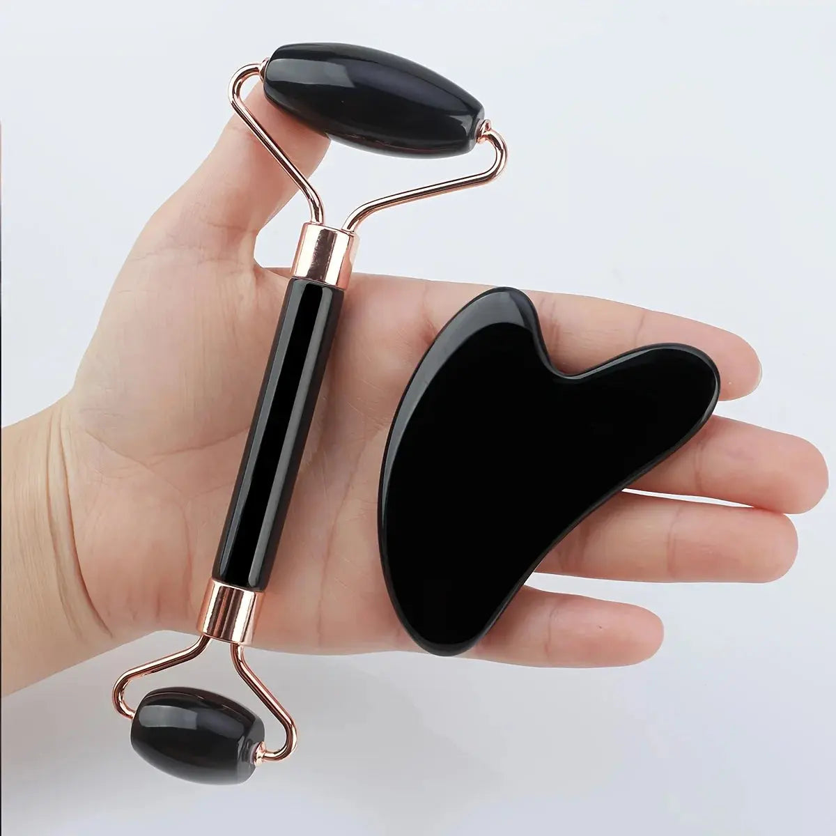 Black handheld facial ice roller and gua sha scraper