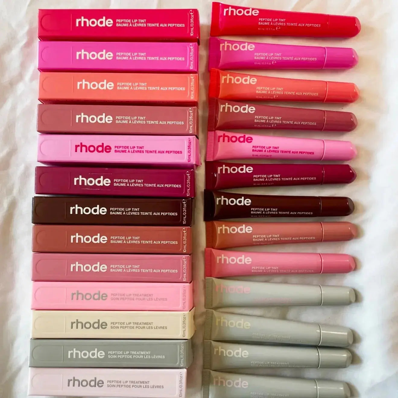 Assorted Rhode lip balm tubes in various colors, stacked on display