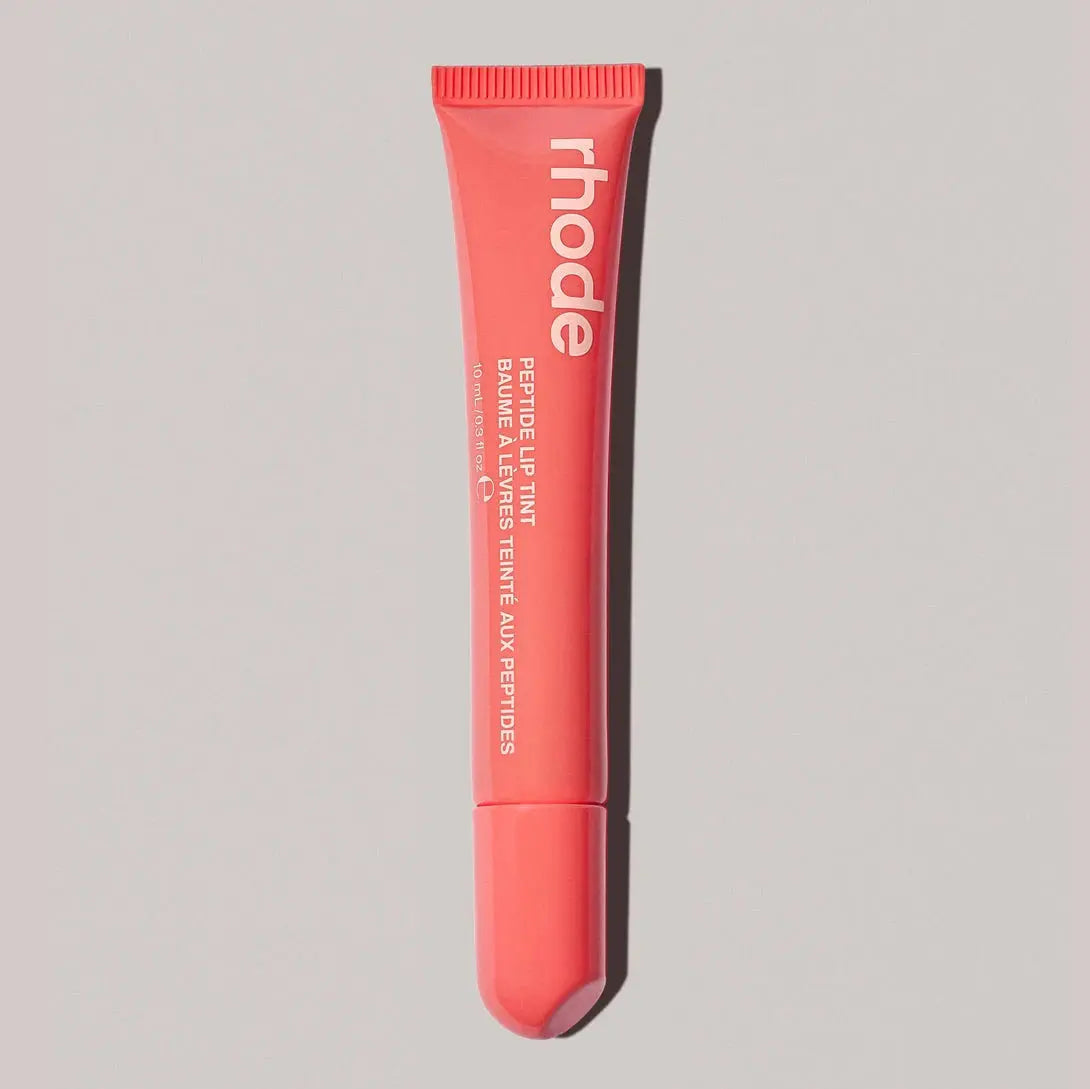 Coral Rhode lip balm tube with ribbed cap and squeeze tip