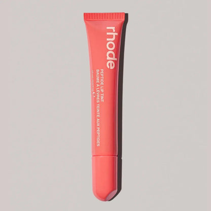 Coral Rhode lip balm tube with ribbed cap and squeeze tip
