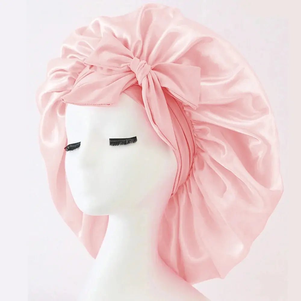 Pink satin bonnet with gathered ruffles, front bow tie, adjustable band