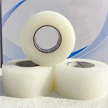 White medical-style facial tape rolls stacked, visible tape adhesive texture