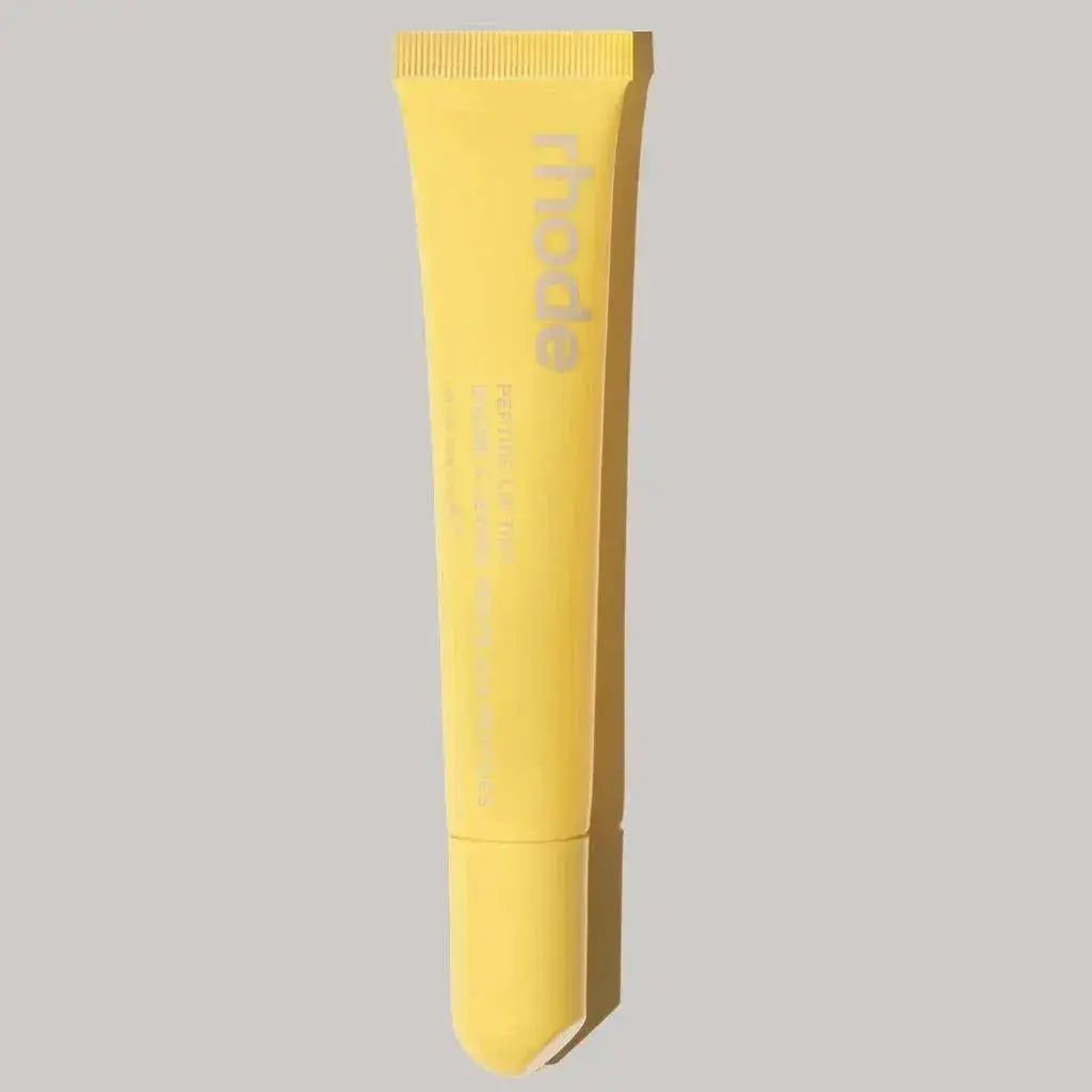 Yellow lip glaze tube with ribbed cap, branded “rhode” plump moisturizing lip gloss