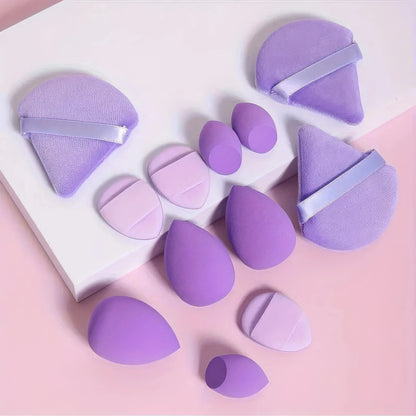 Purple egg-shaped makeup sponges with flat edges, assorted sizes.