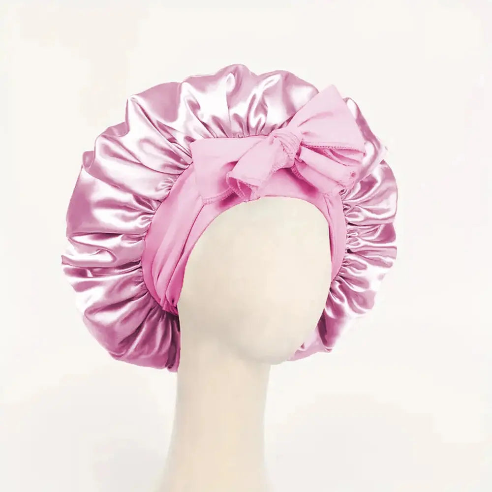 Pink satin hair bonnet with gathered crown and front tie bow for sleep