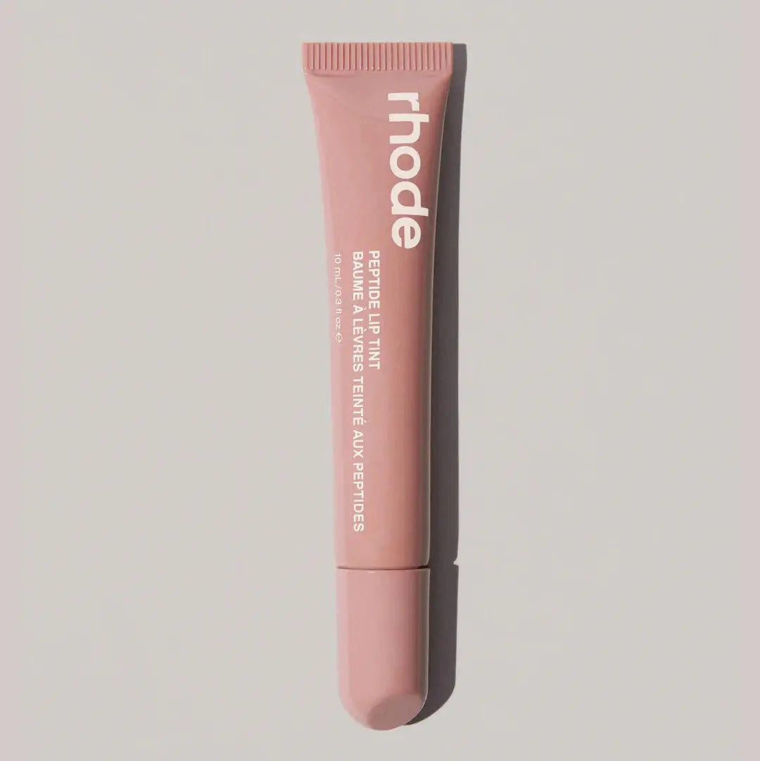 Rhode lip gloss tube in warm nude pink with open applicator tip