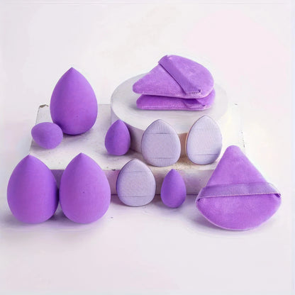 Purple and lavender egg makeup sponges set on a white plate, assorted shapes.