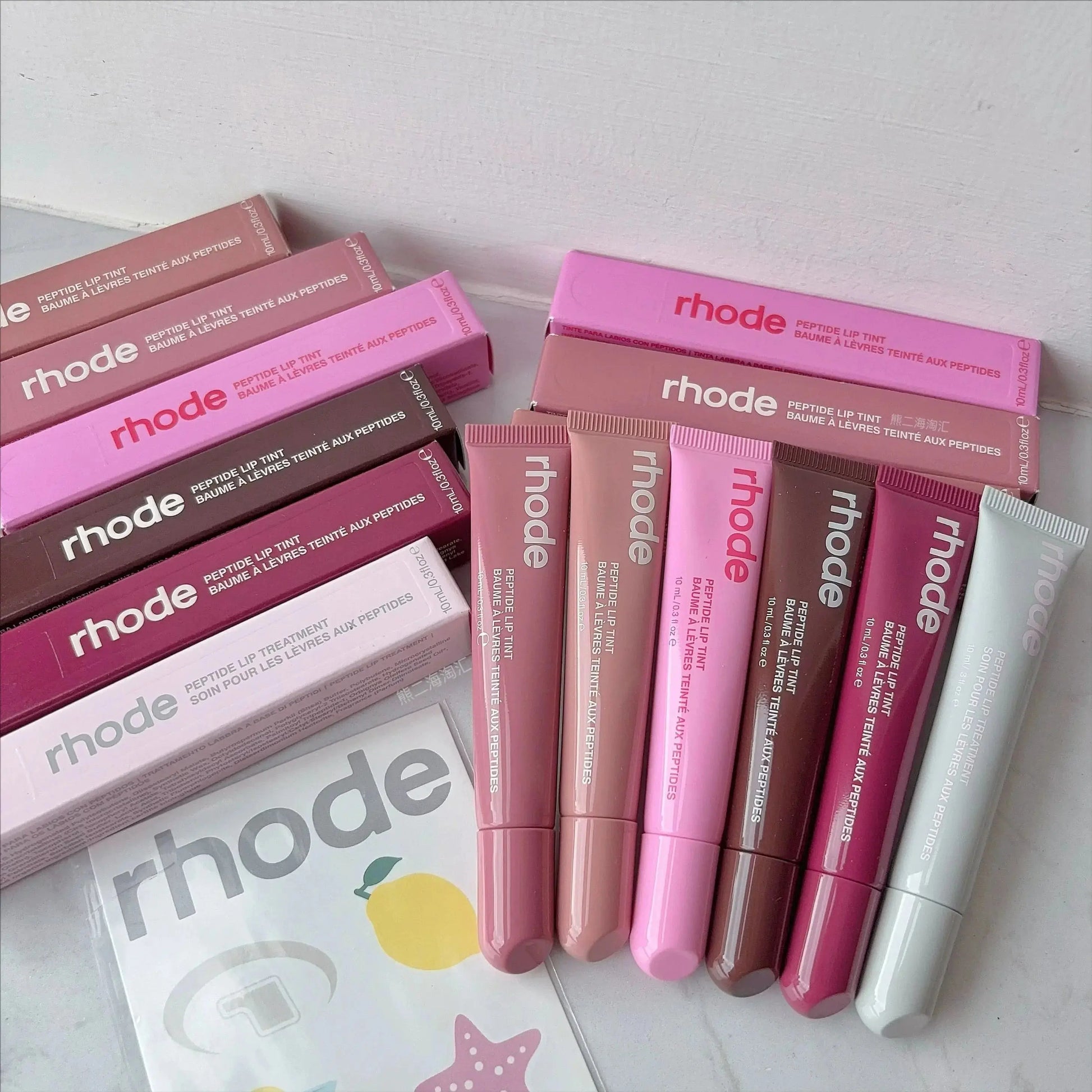 Rhode lip glaze lip glosses with labeled tubes and pink-toned boxes