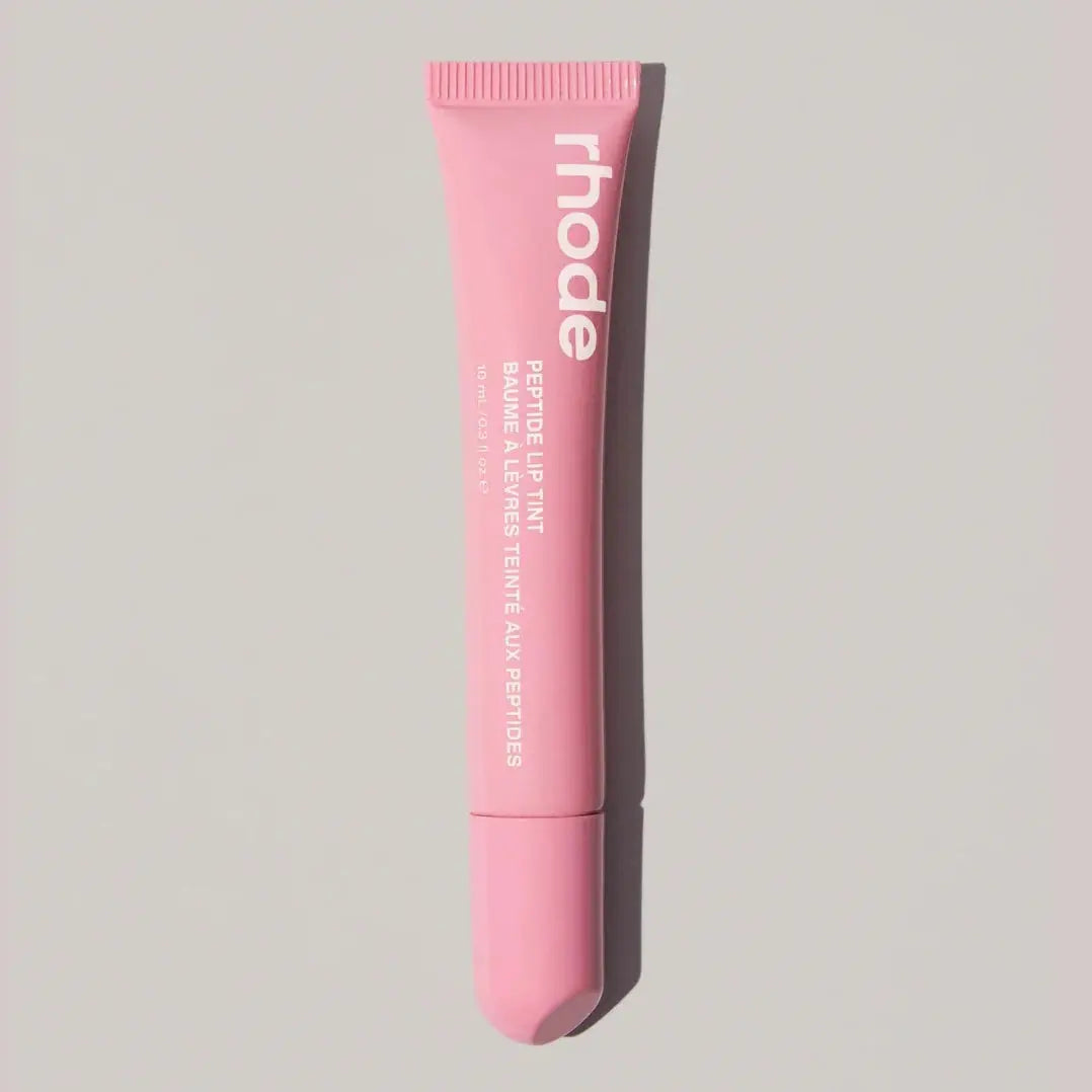 Light pink Rhode lip balm tube with ribbed cap and squeeze tip