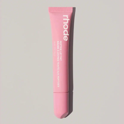 Light pink Rhode lip balm tube with ribbed cap and squeeze tip