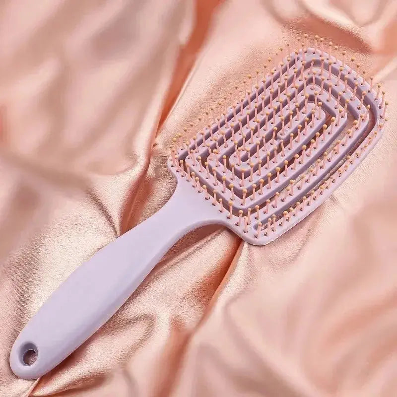 Pink anti-static massage comb brush, close-up of pin tips and handle.